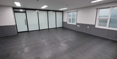 Empty room with tiled floor featuring Hoya Ondol underfloor heating, large frosted glass partition, and two windows on the right wall. - Hoya Ondol Aust